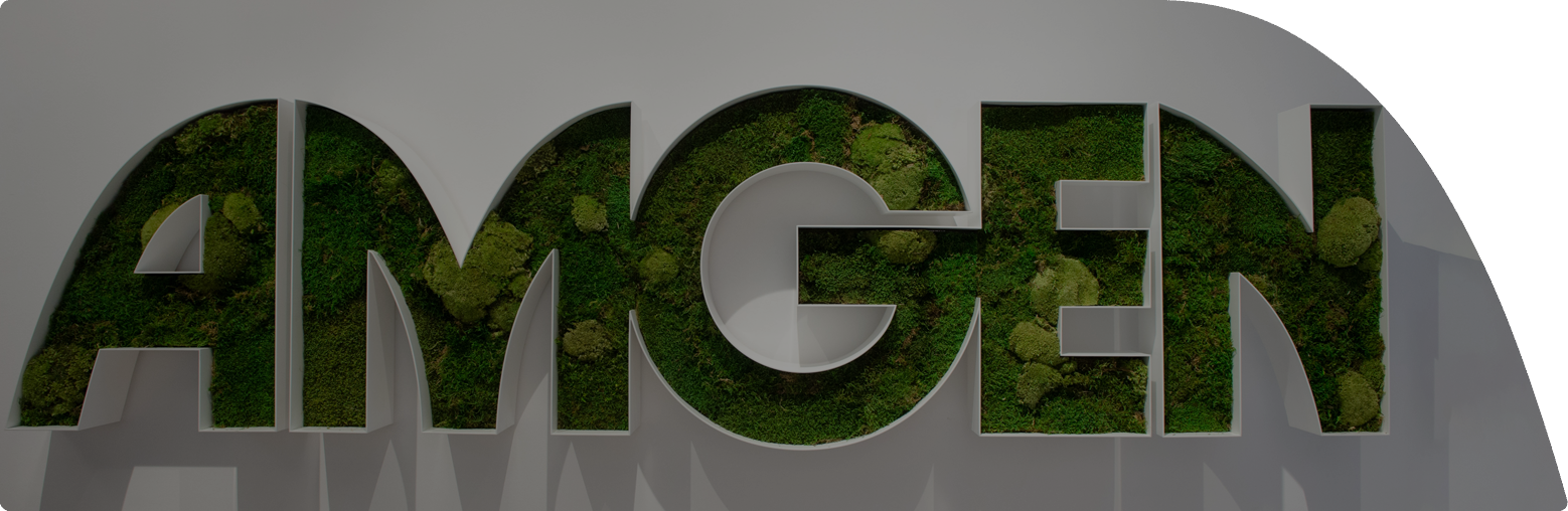 Amgen-Logo mit grüner Moosfüllung an einer weißen Wand