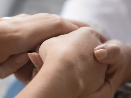 Nahaufnahme zweier Hände, die sich halten. Symbolisch für menschliche Nähe, Vertrauen und therapeutische Unterstützung.